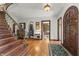 Grand foyer with a wooden staircase, hardwood floors, and an arched front door at 2421 W 39Th St, Indianapolis, IN 46228