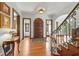 Elegant foyer with hardwood floors, staircase, ornate details, and decorative table with a lamp at 2421 W 39Th St, Indianapolis, IN 46228