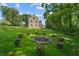 Expansive lawn features an inviting stone home and a unique fire pit area with seating at 2421 W 39Th St, Indianapolis, IN 46228