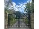 Elaborate black iron gates at stone pillars mark the entrance to a secluded estate at 2421 W 39Th St, Indianapolis, IN 46228