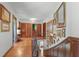 Hallway featuring a staircase, wood floors, many decorative paintings on the walls, and paneled wood doors at 2421 W 39Th St, Indianapolis, IN 46228