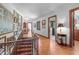Hallway featuring a staircase with decorative paintings, wood floors, paneled wood doors, and warm interior design at 2421 W 39Th St, Indianapolis, IN 46228