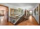 Hallway with stairs, paintings, wood floors, a light fixture, and doorways leading to bedrooms at 2421 W 39Th St, Indianapolis, IN 46228