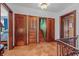Hallway with stairs, wood floors, a light fixture, paneled doors, and doorways leading to bedrooms at 2421 W 39Th St, Indianapolis, IN 46228