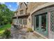 Stone patio with outdoor seating and arched glass door in stone wall surrounded by mature landscaping at 2421 W 39Th St, Indianapolis, IN 46228