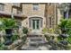 Stone steps leading to arched doorway and outdoor seating on covered porch with manicured lawn and mature foliage at 2421 W 39Th St, Indianapolis, IN 46228