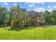Stone home with peaked roof, arched entry to covered patio, attached garage, and manicured front lawn at 2421 W 39Th St, Indianapolis, IN 46228