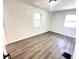 Bright, empty bedroom featuring light-colored walls, gray wood floors and two windows at 2423 E 13Th St, Indianapolis, IN 46201