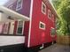 Charming red two-story home boasts crisp white trim and a welcoming front porch with a ceiling fan at 2423 E 13Th St, Indianapolis, IN 46201