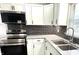 Well-lit kitchen showcasing stainless steel appliances, white cabinets, and a double sink at 2423 E 13Th St, Indianapolis, IN 46201