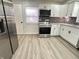 Bright kitchen featuring white cabinets, stainless steel appliances, and gray countertops at 2423 E 13Th St, Indianapolis, IN 46201