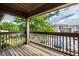 Relaxing outdoor patio with wooden flooring, a view of trees, and parking spaces at 246 Legends Creek Way # Apt 207, Indianapolis, IN 46229