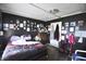 Cozy bedroom with dark walls, wood floor, with pictures displayed and natural light filtering through at 2638 S Mcclure St, Indianapolis, IN 46241