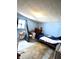 Simple bedroom with blue walls, a dresser, fan, with a bed and window offering a basic resting space at 2638 S Mcclure St, Indianapolis, IN 46241