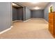 Spacious basement area featuring gray painted walls, neutral carpet, and a wood cabinet against the far wall at 2756 Bluebell E Ct, Columbus, IN 47201