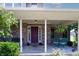 Inviting front porch with cozy seating, brick accents, hanging plants and a colorful front door at 2756 Bluebell E Ct, Columbus, IN 47201