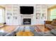Inviting living room with hardwood floors, custom built-ins, a fireplace and a large screen TV at 2756 Bluebell E Ct, Columbus, IN 47201