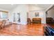 Bright living room featuring hardwood floors, piano, chair, and french doors to a sunroom at 2756 Bluebell E Ct, Columbus, IN 47201