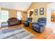 Cozy living room featuring hardwood floors, neutral walls, comfortable seating and natural light from the windows at 2756 Bluebell E Ct, Columbus, IN 47201