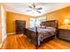 Spacious primary bedroom with dark wood furniture, ceiling fan, and hardwood floors at 2756 Bluebell E Ct, Columbus, IN 47201