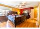 Cozy bedroom with dark wood furniture, colorful accent wall, and hardwood flooring at 2756 Bluebell E Ct, Columbus, IN 47201