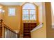 Bright staircase featuring hardwood steps, railing, and large arched window at 2756 Bluebell E Ct, Columbus, IN 47201