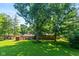 Expansive backyard featuring mature trees, lush lawn, a storage shed and brick home at 2808 Woodside Dr, Plainfield, IN 46168