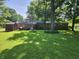 Expansive backyard with mature trees, a storage shed, and a brick home exterior at 2808 Woodside Dr, Plainfield, IN 46168