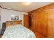 Bedroom with hardwood floors and knotty pine featuring built-in shelves above the headboard and a closet at 2808 Woodside Dr, Plainfield, IN 46168