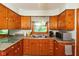 Functional kitchen with wooden cabinetry overlooking the lush backyard at 2808 Woodside Dr, Plainfield, IN 46168