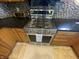 Stainless steel gas range with black countertop and neutral floor mat adds a touch of elegance to this classic kitchen design at 3154 Beach Blvd, Cicero, IN 46034