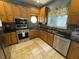 Well-lit kitchen boasts custom wood cabinets, stainless steel appliances, and black countertops, offering a blend of classic style and modern amenities at 3154 Beach Blvd, Cicero, IN 46034