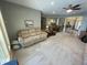 Open-concept living area with neutral carpet, featuring beige couches, decorative ships, and seamless flow to dining area at 3154 Beach Blvd, Cicero, IN 46034