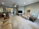 Open-concept living space with neutral carpet, ceiling fan, comfortable couches, and seamless flow to the dining area and entry at 3154 Beach Blvd, Cicero, IN 46034
