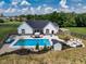 Aerial view of the backyard with a pool, patio, shed, and fire pit with seating at 320 Briar Hill Dr, Whiteland, IN 46184