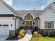 Home's inviting front entrance with detailed trim, a peaked roof and elegant landscaping at 320 Briar Hill Dr, Whiteland, IN 46184
