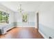 Sunny dining room with hardwood floors, updated chandelier, and natural light from the windows at 328 Marine Dr, Anderson, IN 46016