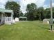Expansive backyard featuring a well-manicured lawn, an outdoor picnic structure and trees at 3310 W State Road 58, Seymour, IN 47274