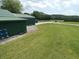 Expansive backyard with lush green grass, a storage building and a long driveway at 3310 W State Road 58, Seymour, IN 47274