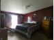 View of the bedroom featuring a queen bed, neutral carpet and red painted walls at 3310 W State Road 58, Seymour, IN 47274