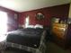 View of the bedroom featuring a queen bed with black blanket, bureau, and decor at 3310 W State Road 58, Seymour, IN 47274