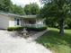 Charming home exterior featuring a welcoming porch, a white picket fence, and beautifully landscaped surroundings at 3310 W State Road 58, Seymour, IN 47274
