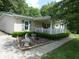 Manicured garden area and covered porch add to the charm of this home at 3310 W State Road 58, Seymour, IN 47274