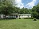 Single story home on a large lot with a mature tree and garden landscaping at 3310 W State Road 58, Seymour, IN 47274