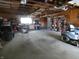 Garage interior showing beams, a small workshop, shelving and riding mower at 3310 W State Road 58, Seymour, IN 47274