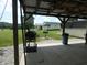 Covered outdoor kitchen area equipped with a grill and ample space for cooking and entertaining in a serene setting at 3310 W State Road 58, Seymour, IN 47274