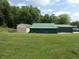 Lawn view featuring a series of storage sheds, set against a background of trees and blue sky at 3310 W State Road 58, Seymour, IN 47274