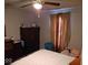 Comfortable bedroom featuring a ceiling fan, dresser, and natural light from the window at 3330 S Mooresville Rd, Indianapolis, IN 46221
