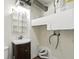 Compact laundry bathroom featuring a sink with wooden cabinets, a toilet and shelving at 3343 Ashley Ln, Indianapolis, IN 46224