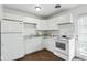 Well-lit kitchen featuring white appliances, ample counter space and vinyl wood-look floors at 3343 Ashley Ln, Indianapolis, IN 46224
